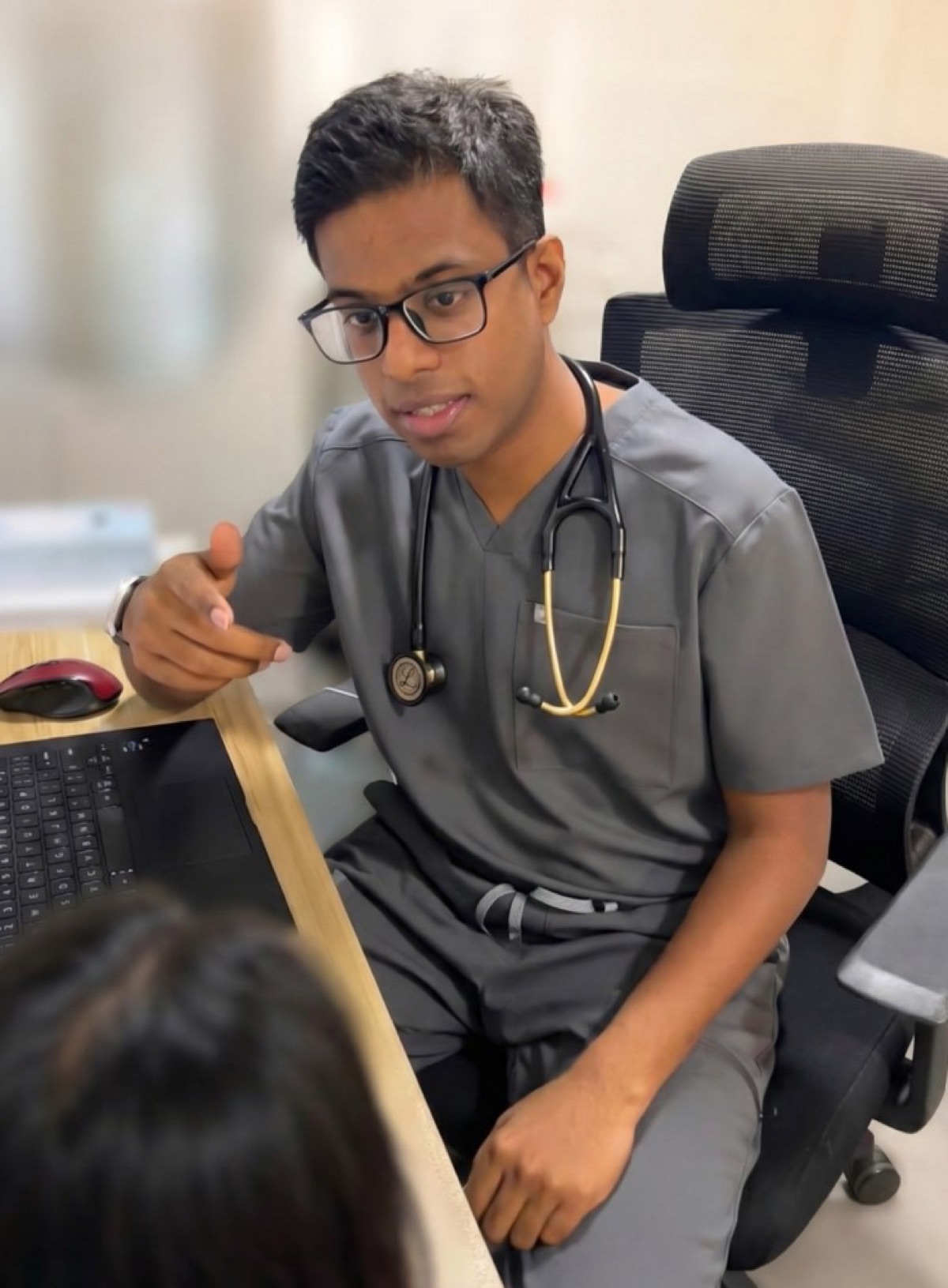 Dr. Dhivian in consultation at Angsana Medical. Engaged, attentive, taking the time to listen.